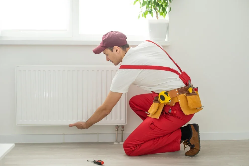 Un professionnel installe un radiateur